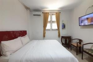 En eller flere senge i et værelse på OYO 92463 Deli Hotel Medan