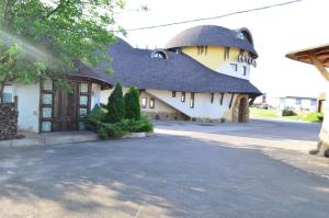 a building with a round roof and a driveway at Hotel Veles in Zolotonosha