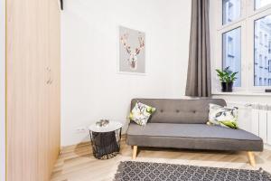 羅茲的住宿－CITYSTAY Narutowicza Lodz Apartment，客厅设有灰色的沙发和窗户。