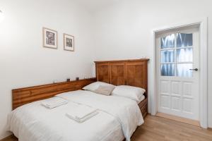 una camera con un grande letto con testiera in legno di Charming Apartment in Lesser Town a Praga