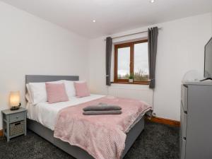 a bedroom with a bed with a pink blanket and a window at Bluebell Lodge, Meadow view lodges in Burnham on Sea