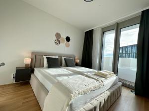 a bedroom with a large bed and a large window at The View 16.01 - Quartier Belvedere in Vienna