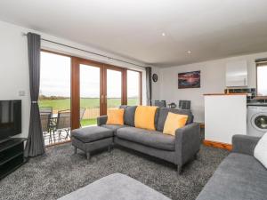 een woonkamer met een bank en een tv bij Delphine Lodge, Meadow View Lodges in Burnham on Sea