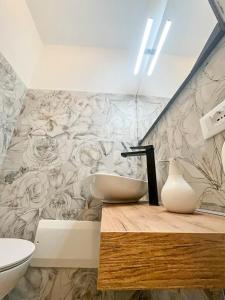 a bathroom with a sink and a flower mural on the wall at Le Grotte delle Meraviglie in Lustignano