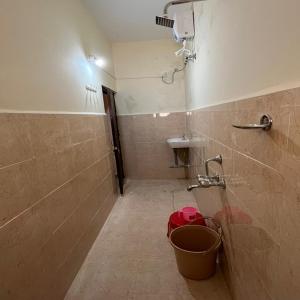 a bathroom with a shower and a bucket at New Bombay Lodge in Nagpur