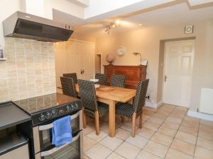 a kitchen with a wooden table and chairs and a stove at Ravens Heugh in Morpeth