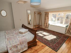 a bedroom with a bed and a rug and a window at Ravens Heugh in Morpeth