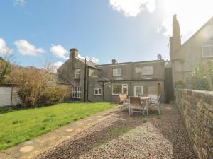 a house with a table and chairs in the yard at Ravens Heugh in Morpeth