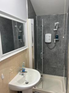 La salle de bains est pourvue d'un lavabo et d'une douche. dans l'établissement No.9 Cosy Private Studio in Moseley, Birmingham, à Birmingham