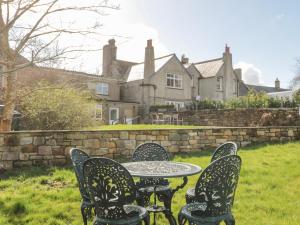 una mesa y sillas frente a una casa en Bridge End Cottage en Morpeth