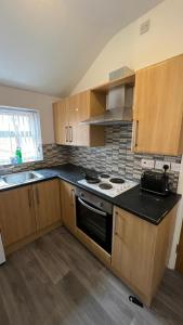 a kitchen with wooden cabinets and a stove top oven at No.9 Cosy Private Studio in Moseley, Birmingham in Birmingham