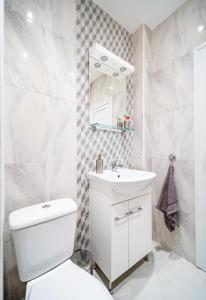 W łazience znajduje się toaleta, umywalka i lustro. w obiekcie Bright and Elegant Apartment w Warnie