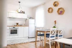 a kitchen with white appliances and a table and chairs at Bright and Elegant Apartment in Varna City