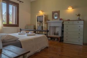 a bedroom with a bed and a dresser at Odysseas Pelion House in Kalamaki