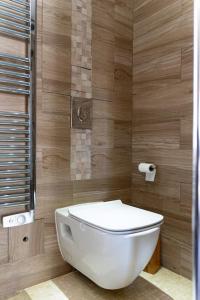 a white toilet in a bathroom with wooden walls at Appartement proche DisneyLand et Paris in Bussy-Saint-Georges