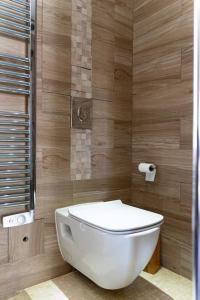 - białą toaletę w łazience z drewnianymi ścianami w obiekcie Appartement proche DisneyLand et Paris w mieście Bussy-Saint-Georges
