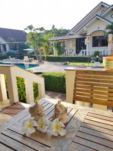 House in Ban Phe, Thailand في رايونغ: طاولة خشبية عليها زهور بيضاء
