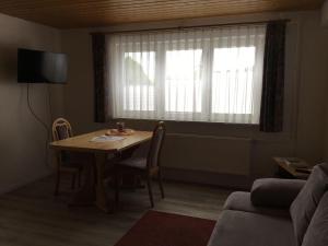 a living room with a table and a window at Haus-Fechtig-Wohnung-TypB-Parterre in Bonndorf im Schwarzwald