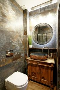 ein Badezimmer mit einem WC, einem Waschbecken und einem Spiegel in der Unterkunft Willa Park Międzyzdroje in Misdroy