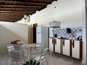 a kitchen with a table and chairs and a refrigerator at Kadosh in São Luís