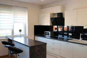 a kitchen with white cabinets and a black counter top at Luxury apartment Anabella in Varaždin