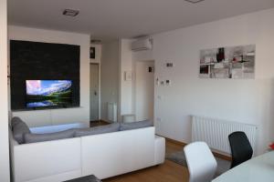 a living room with a white couch and a tv at Luxury apartment Anabella in Varaždin