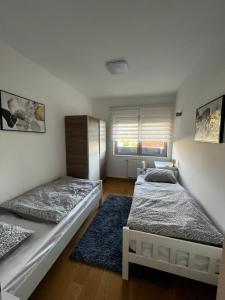 a bedroom with two beds and a blue rug at Luxury apartment Anabella in Varaždin