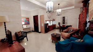 een woonkamer met banken en stoelen en een tafel bij Villa Padi Cangkringan in Yogyakarta