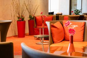 una habitación con almohadas de color naranja y una mesa con flores en Hotel Roth am Strande, en Westerland