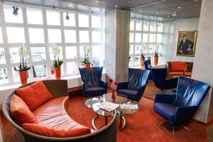 a waiting room with chairs and a table at Hotel Roth am Strande in Westerland