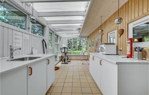 MartofteにあるBeautiful Home In Martofte With Kitchenの白いキャビネットと大きな窓付きのキッチン