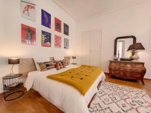 a bedroom with a large bed and a mirror at Escale citadine au centre d'Avignon, climatisation, appartement de charme, spacieux et lumineux in Avignon