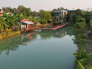 un grupo de casas en un río con edificios en Falik Farm Stay en Phra Nakhon Si Ayutthaya