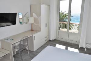 フィナーレ・リーグレにあるHotel Boncardoの海の景色を望む白い客室で、デスクが備わります。
