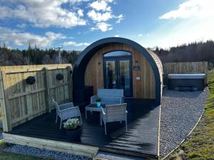 a gazebo with a table and chairs on a deck at Highland Premier Glamping Pods in Beauly