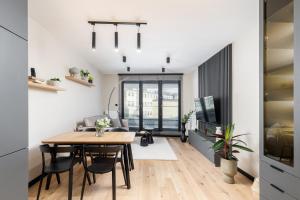 a dining room and living room with a table and chairs at Malila Premium Apartments Cracow Centre Wiślane Tarasy 2 0 in Krakow