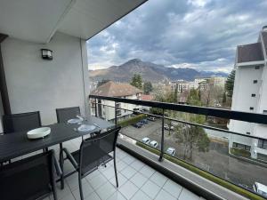een balkon met een tafel en uitzicht op een straat bij Le Mont-Veyrier, parking et vue in Annecy