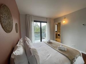 a bedroom with a white bed with a window at Le Mont-Veyrier, parking et vue in Annecy