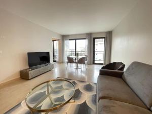 een woonkamer met een bank en een tafel bij Le Mont-Veyrier, parking et vue in Annecy