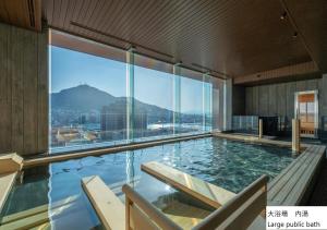 une grande piscine avec vue sur les montagnes dans l'établissement La Vista Hakodate Bay Annex, à Hakodate