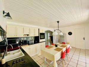a kitchen with a table and red chairs in it at Aux Lauriers d'Adhémar in La Garde-Adhémar