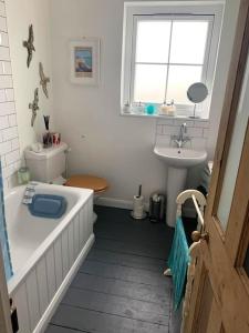 a bathroom with a bath tub and a sink at Heart house fisherman’s cottage in Kent