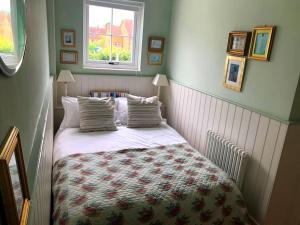 Habitación pequeña con cama y ventana en Heart house fisherman’s cottage, en Kent