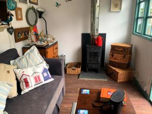 uma sala de estar com um sofá e um fogão a lenha em Heart house fisherman’s cottage em Kent