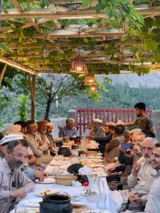 a group of people sitting at a long table at Dumani Nagar Hotel & Resort in Hunza Valley