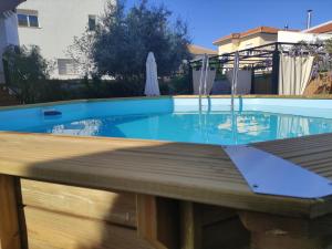 a pool with a wooden deck and a swimming pool at Villa María, Piscina y Spa exterior privado in Belicena