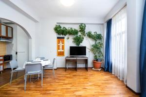 een eetkamer met een tafel en een tv bij Family Hotel Central in Shumen