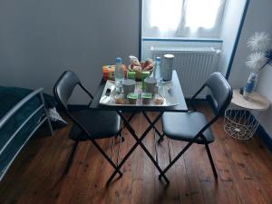 una mesa con sillas y comida en una habitación en Les chambres au pied du Rey, en Sainte-Colome
