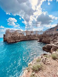 a group of buildings on a cliff next to the ocean at Dimora Punta Azzurra in Polignano a Mare