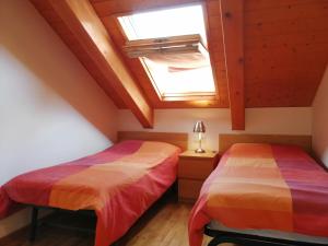 two beds in a room with a skylight at Apartaments Pleta Bona in Pla de l'Ermita